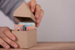 Foto: Schachtel in Hausform mit Geldscheinen
